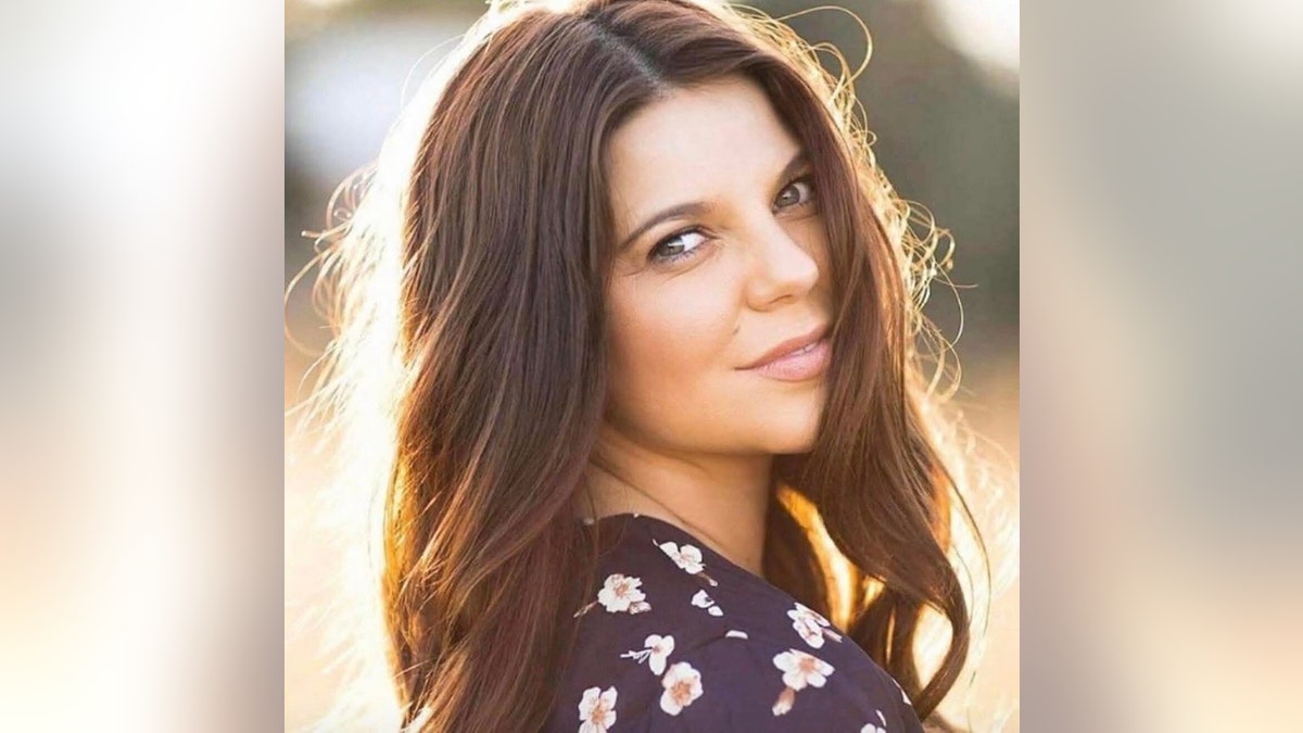 Amy Duggar King taking a glamorous photo outdoors ahead of her book release.