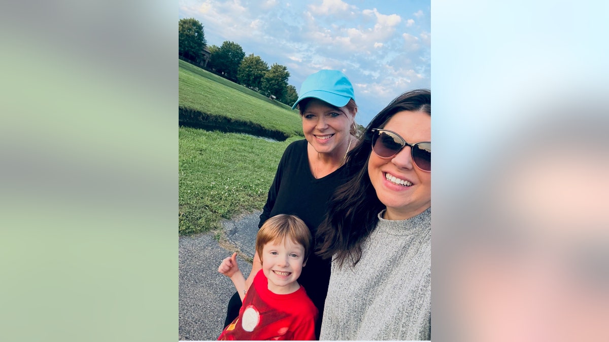 Amy Duggar King taking a selfie with her mom and son as they smile.