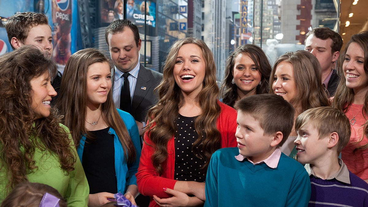 The Duggar children smiling together at a studio.