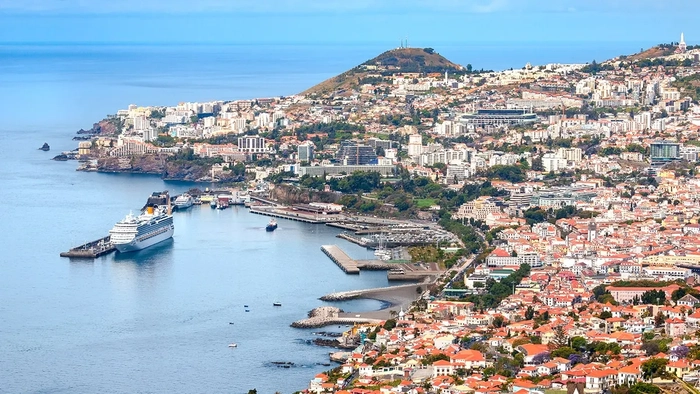 Vista de los edificios de Madeira, colinas con el crucero en el puerto