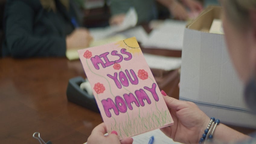 A letter from Maya to her mother that reads, "Miss you mommy," in pink lettering