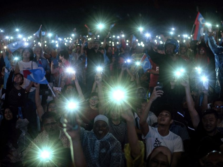 подростки держат в руках фонарики для смартфонов