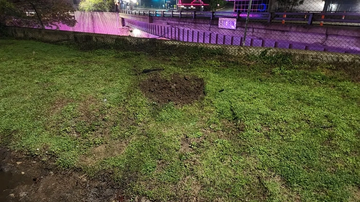 дренажная канава, травянистая местность и забор имеют следы от автомобиля после аварии