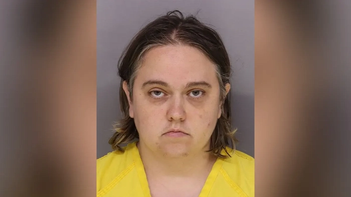 La madre y otros dos progenitores han sido detenidos por el asesinato de un niño después de que los abuelos contrataran a un investigador privado para investigar la «casa de los horrores» Fotografía de fichaje de Kaitlin Evans, vestida con un uniforme carcelario amarillo sobre un fondo gris.