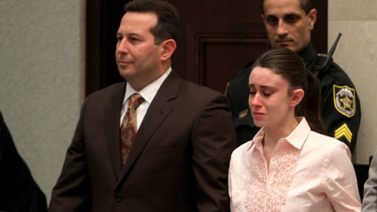 Casey Anthony se toma de la mano con sus abogados defensores, José Báez, a la izquierda, y Dorothy Clay Sims, mientras escuchan el veredicto en el Juzgado del Condado de Orange en Orlando, Florida., Martes 5 de julio de 2011. El jurado absolvió a Anthony de asesinar a su hija, Caylee. (Foto AP / Red Huber, Piscina)