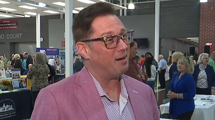 Чад Алан-Карр в очках и розовом костюме во время интервью