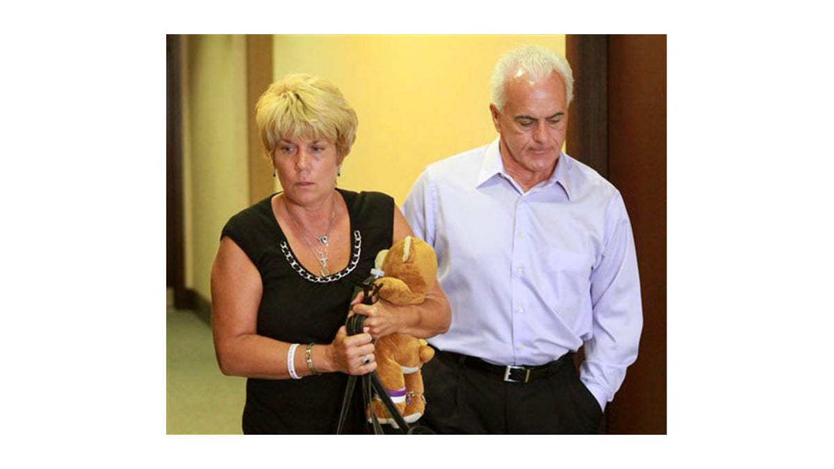 Cindy Anthony, sosteniendo un oso de peluche, y su esposo, George Anthony, abandonan la sala del tribunal después de escuchar la primera parte de los argumentos iniciales del estado en el juicio por asesinato en primer grado de su hija, en el Juzgado del Condado de Orange, en Orlando, Florida., Martes 24 de mayo de 2011. Su hija, Casey Anthony, está siendo juzgada por el asesinato de su hija de 2 años. (Foto AP / Joe Burbank, Piscina) 