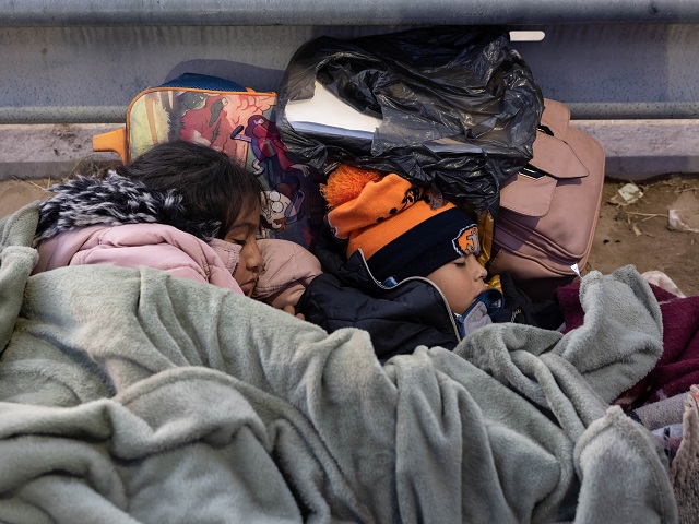 EL PASO, TEXAS - DECEMBER 22: Children from Colombia sleep while spending the night camped with their family alongside the U.S.-Mexico border fence on December 22, 2022 in El Paso, Texas. A spike in the number of migrants seeking asylum in the United States has challenged local, state and federal authorities. The numbers are expected to increase as the fate of the Title 42 authority to expel migrants remains in limbo pending a Supreme Court decision expected after Christmas. (Photo by John Moore/Getty Images)