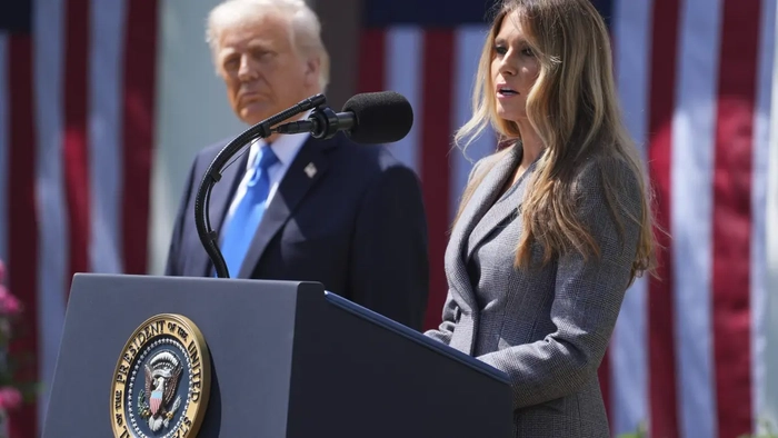 Первая леди Мелания Трамп выступает, а президент Дональд Трамп слушает в Розовом саду Белого дома