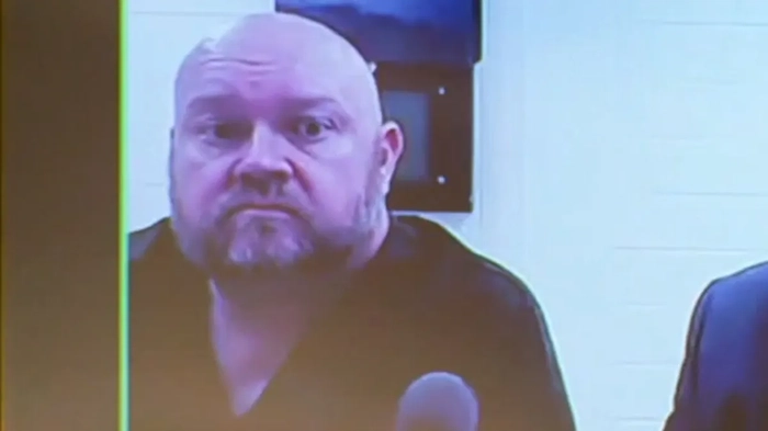 Бывший директор школы Джереми П. Уильямс показан на экране во время выступления в суде.