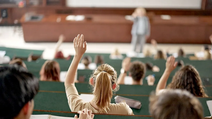 una niña levanta la mano en clase