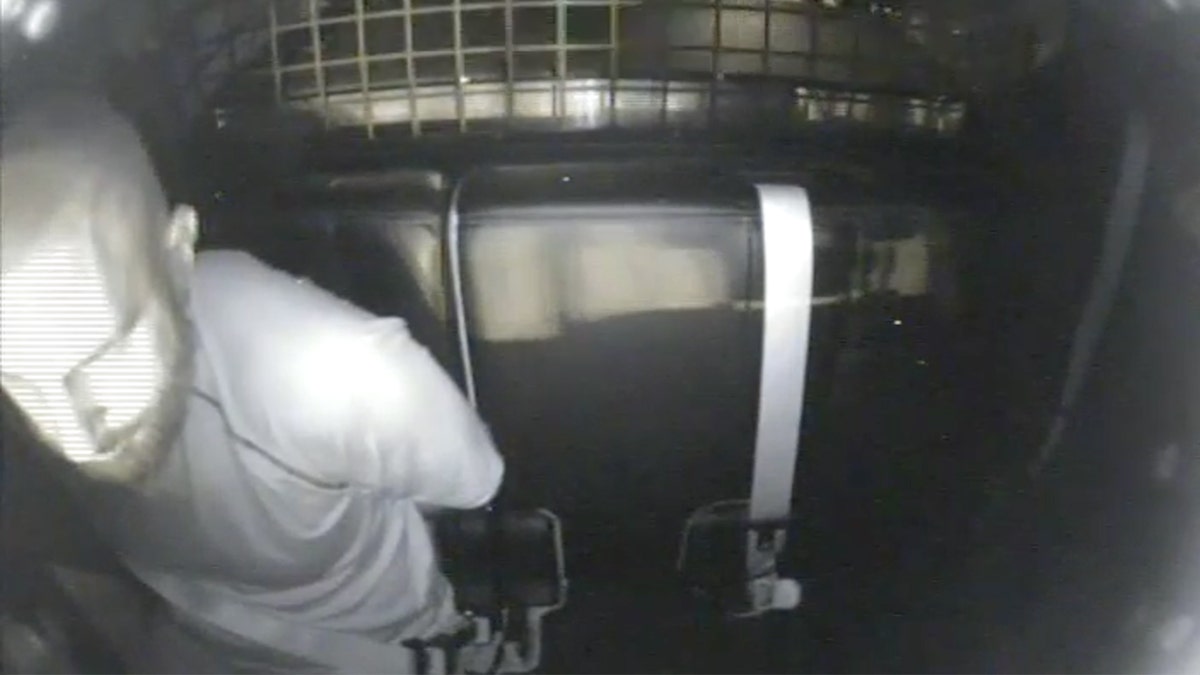 Jeremy Guthrie handcuffed in back of police cruiser