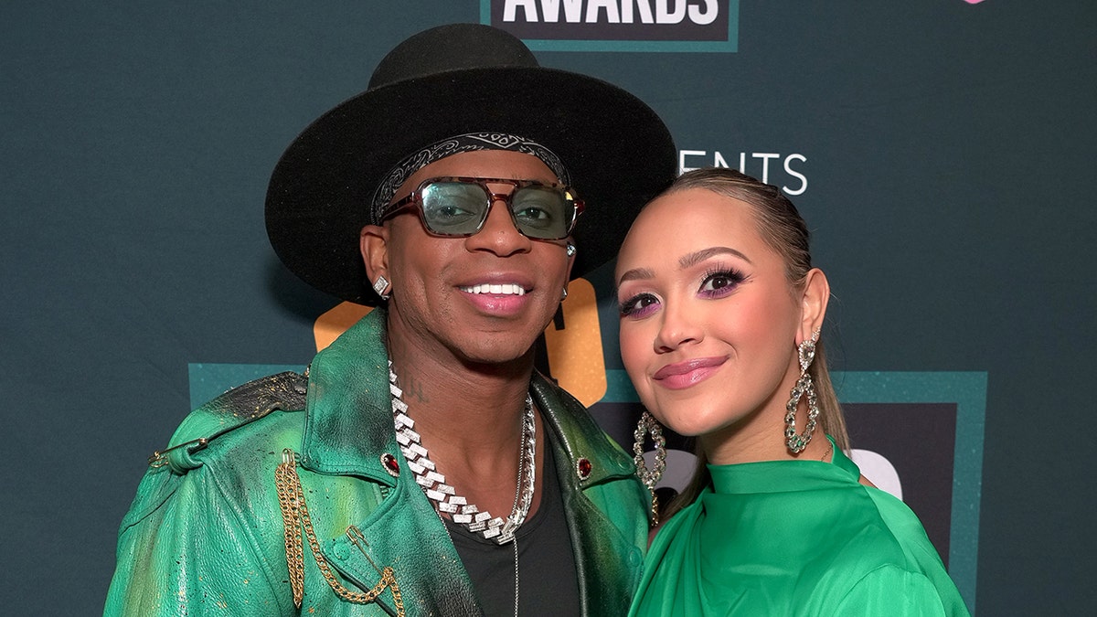 Jimmie Allen smiling with his wife
