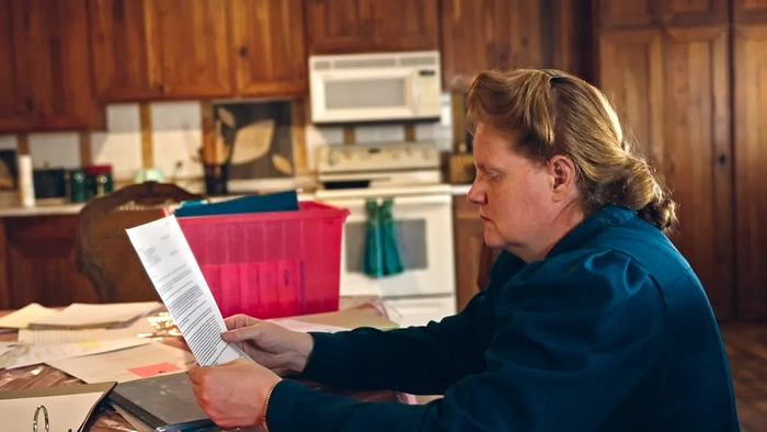 Джулия Джонсон стоит в сцене из фильма "Верь мне: Ложный пророк, 1 сезон