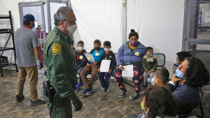 Los migrantes son procesados en el área de admisión de la instalación de Aduanas y Protección Fronteriza de EE.UU., el principal centro de detención para niños no acompañados en el Valle del Río Grande, en Donna, Texas, el martes mar. 30, 2021.