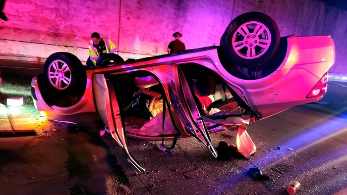 перевернувшаяся машина на шоссе с открытыми дверями и в окружении спасателей