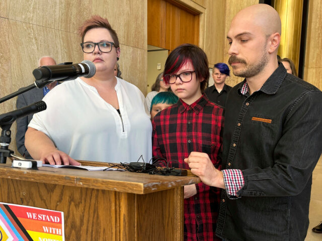 Parents Devon and Robert Dolney, of Fargo, N.D., stand with their 12-year-old child, Tate,