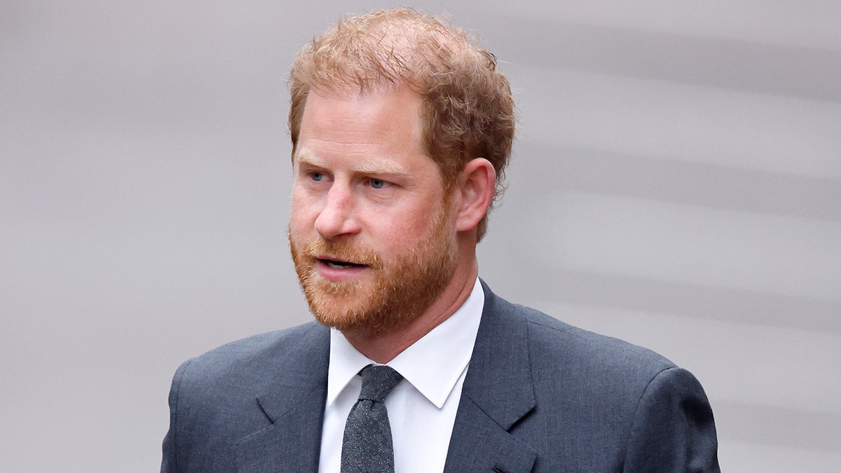 El príncipe Harry con traje gris y corbata afuera en Londres