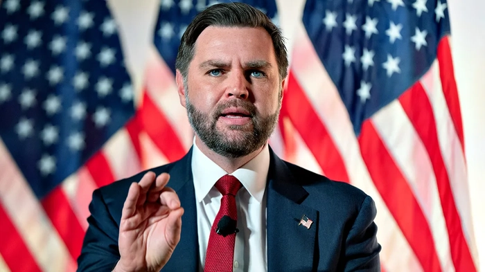 Вице-президент Джей Ди Вэнс жестикулирует во время выступления перед американскими флагами