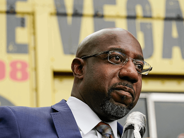 El candidato demócrata al Senado, Raphael G Warnock, habla ante una multitud durante un "Salgan de la