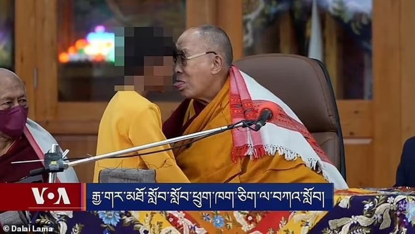 Dalai Lama heel dicht bij een kind, hem aanraken met zijn tong.