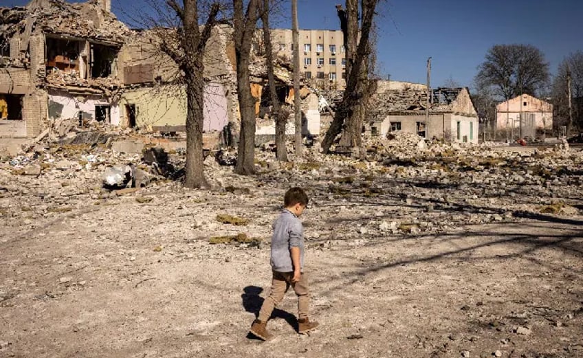 Child walking alone among buildings destroyed by shelling in Ukraine
