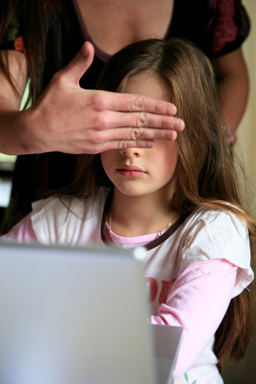 Photo of a woman covering a child's eyes, protecting her from what she was seeing on internet.